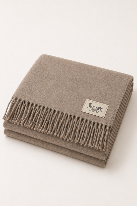 Baby-Alpaka-Decke Taupe zusammengefaltet, Draufsicht mit sichtbarem Label und Fransen