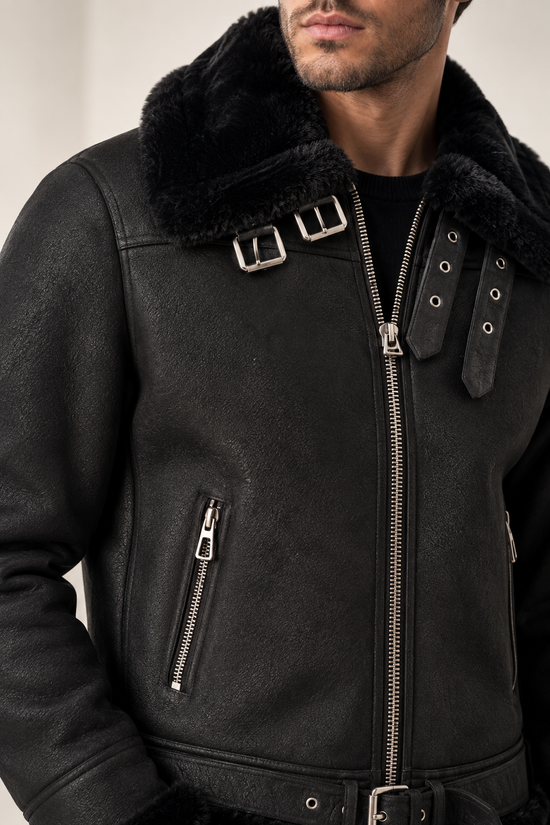 Detailansicht der schwarzen Herren-Lammfelljacke mit Reißverschluss, Kragen und Schnallen