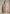 Beige Curly-Lammfelljacke für Damen als Frontansicht am Modell vor grauem Hintergrund.