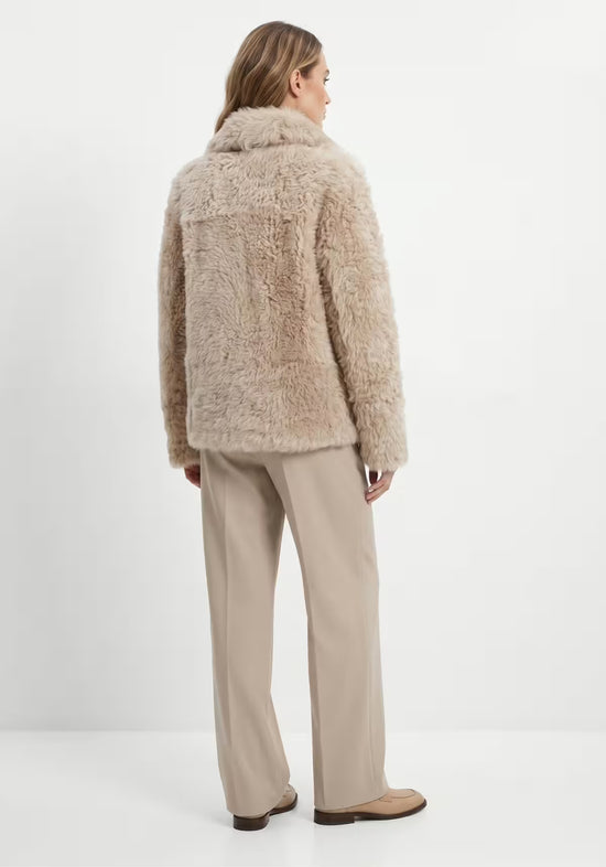 Rückansicht der beige Curly-Lammfelljacke für Damen mit geradem Schnitt.