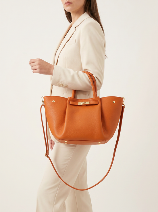 Damen-Handtasche aus Leder in Cognac am Modell, als Schulter- und Henkeltasche getragen.