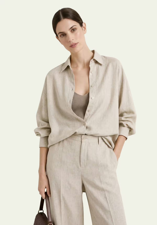 Offenes Damenhemd aus Leinen in Beige über einem Top, kombiniert mit passender Hose.