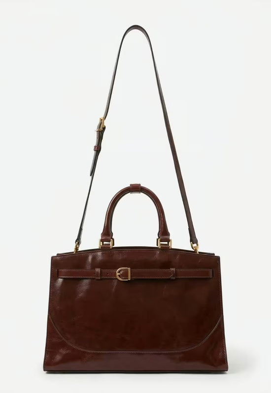 Braune Leder-Hobo-Tasche mit langem Schulterriemen und zwei Tragegriffen auf hellem Hintergrund.