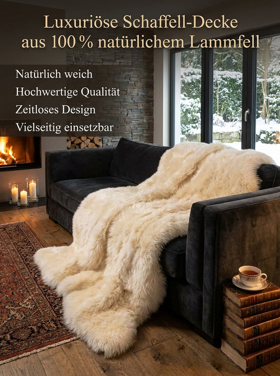Lammfelldecke aus Lammfell in Champagner auf einem dunklen Sofa drapiert.