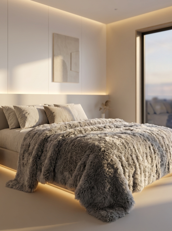 Grau melierte Lammfelldecke aus Lammfell auf einem Bett mit Kissen drapiert
