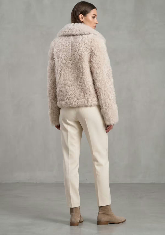 Curly Lammfelljacke für Damen in Creme-Beige von hinten, getragen mit kurzem Schnitt und weichem Fell.