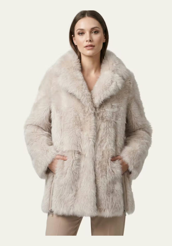 Damen Lammfelljacke in Creme-Beige am Modell von vorn, mit weitem Kragen und Eingrifftaschen.