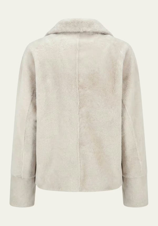 Detail der creme-beigen Lammfelljacke für Damen von hinten mit markanter Mittelnaht und weichem Fell.