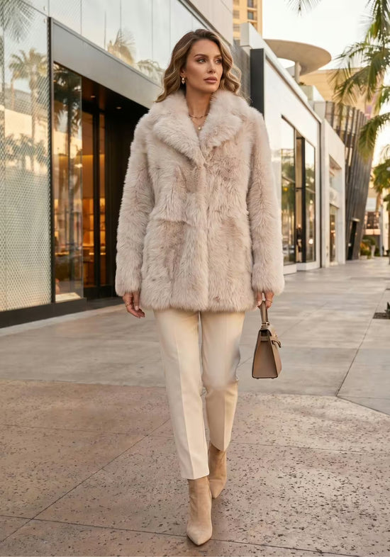 Damen Lammfelljacke in Creme-Beige als Outdoor-Styling mit Hose, Stiefeletten und Handtasche.