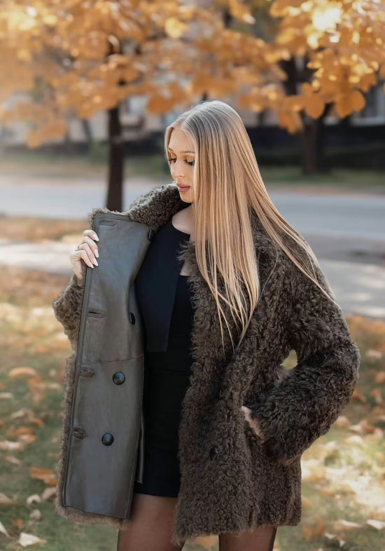 Geöffnete Lammfelljacke aus Curly-Lammfell in Oliv, mit sichtbarer Innenseite und Knopfleiste.