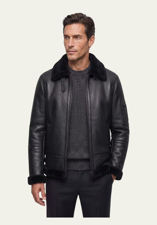 Schwarze Herren-Lammfelljacke am Modell, offen getragen mit sichtbarem Kragen und geradem Schnitt.