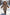Kind trägt eine beige Lammfelljacke mit Kapuze und Fellbesatz beim Laufen im Schnee