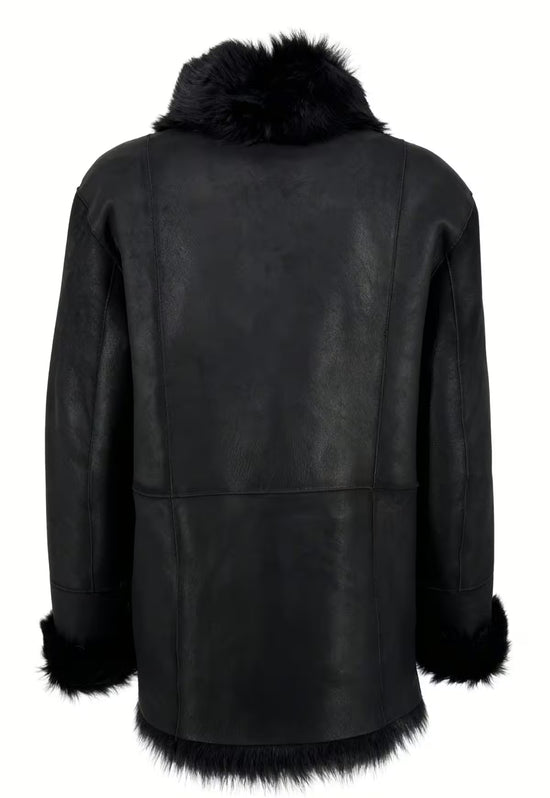 Rückseite einer schwarzen Lammfelljacke für Damen mit glatter Lederseite und Fellsaum.