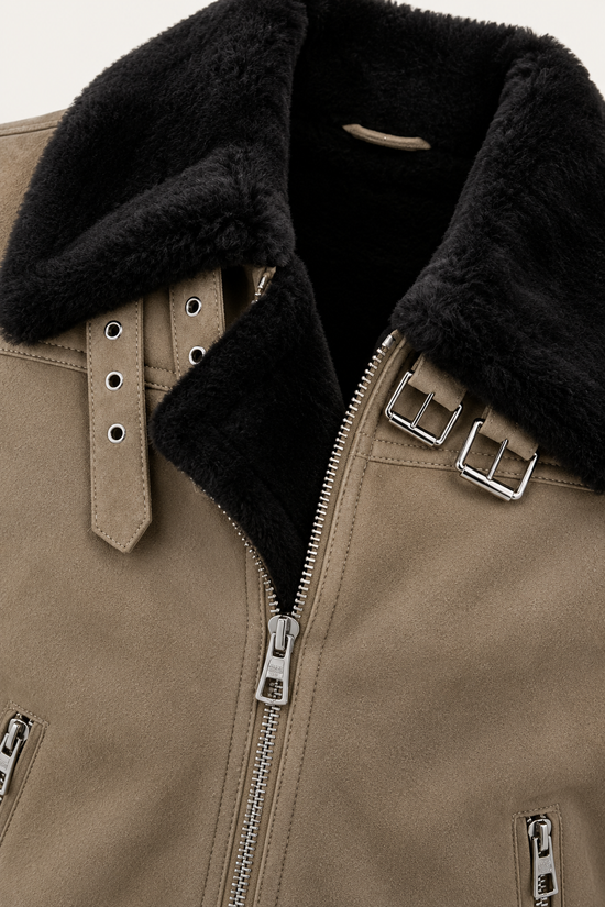 Detail der Lammfelljacke in Camel mit schwarzem Lammfellkragen, Reißverschluss und Schnallen