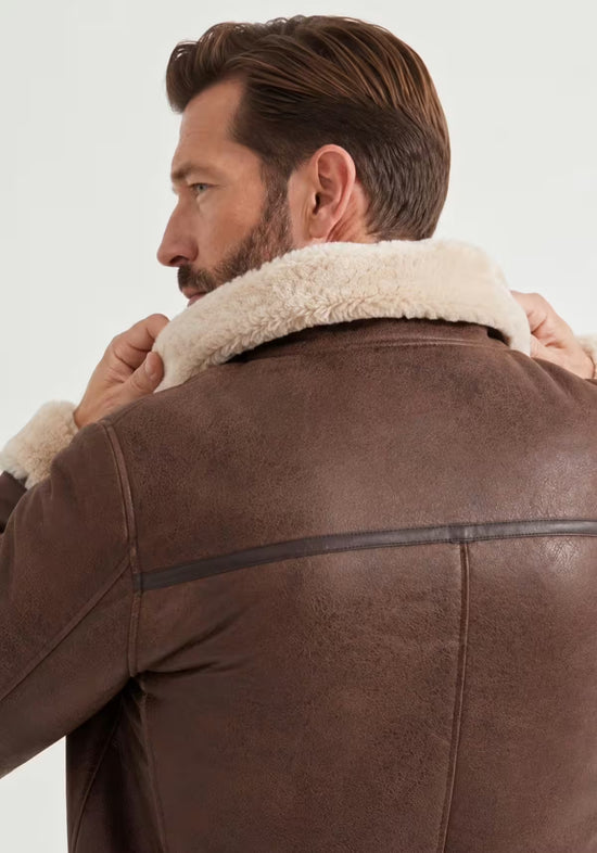 Nahaufnahme der Herren-Lammfelljacke in Mahagoni mit hochgestelltem Lammfell-Kragen.