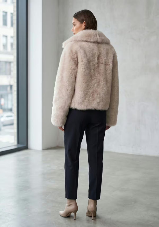 Rückansicht der creme-beigen Lammfelljacke aus Sheepskin mit kurzem Schnitt und breitem Kragen.