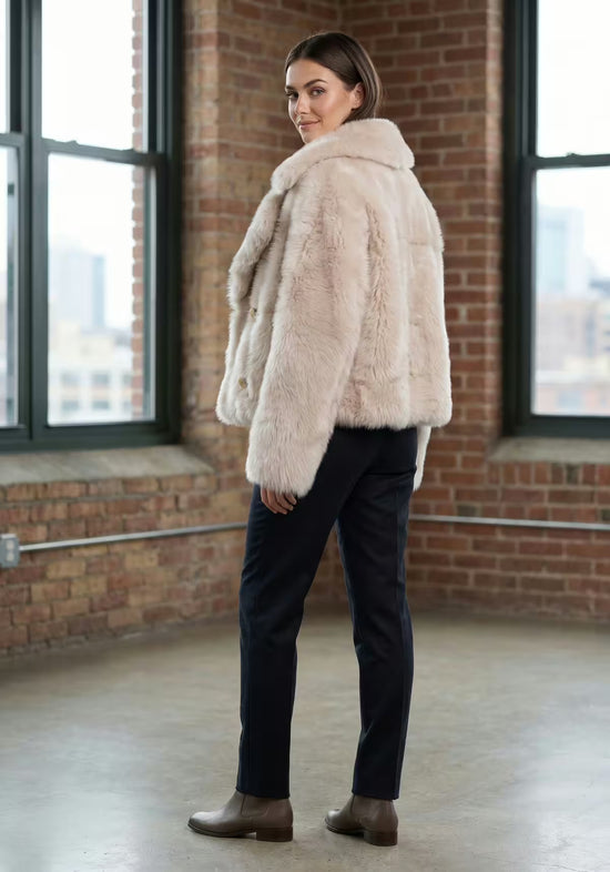 Creme-beige Lammfelljacke aus Sheepskin am Modell in seitlicher Ansicht von hinten.