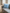 Himmelblaues Lammfellkissen auf dem grauen Sofa in einem hellen Wohnraum