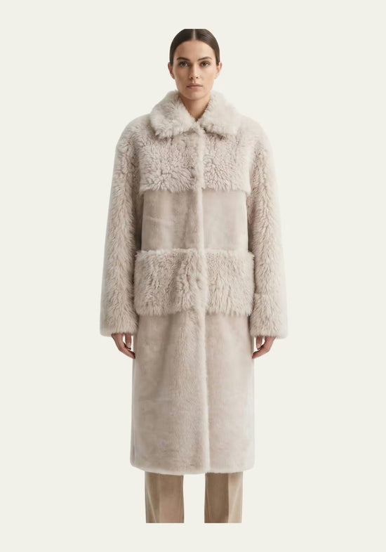 Damen-Lammfellmantel in Beige als Frontalansicht am Modell mit geradem Schnitt und Stehkragen.