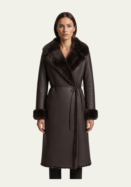Brauner Lammfellmantel für Damen an Model von vorne mit breitem Pelzkragen und umgelegten Ärmeln.
