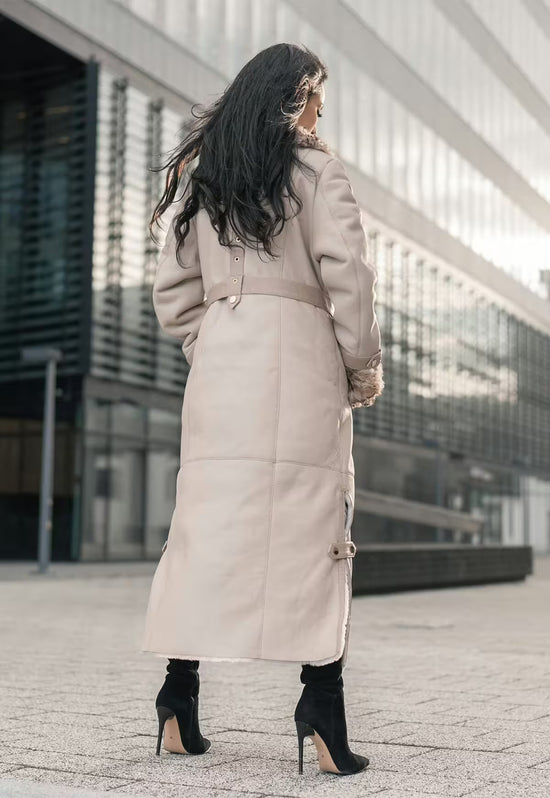 Lammfellmantel für Damen in Beige von hinten, mit Gürtel, glatter Rückenpartie und langem Saum.