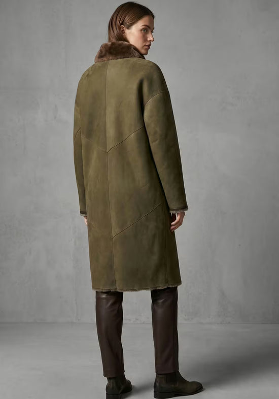Damen-Lammfellmantel in Oliv von hinten getragen, mit gerader Silhouette und braunem Kragen.