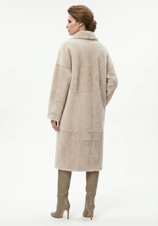 Lammfellmantel aus Shearling in Creme, an der Modelträgerin von hinten.