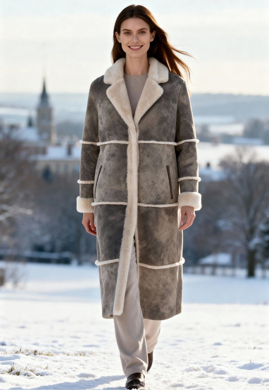 Lammfellmantel aus Shearling für Damen in Taupe, im Schnee getragen.