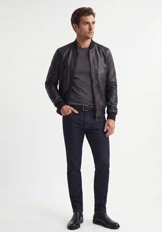 Herren-Lederjacke aus schwarzem Lammnappaleder am Modell, mit Stehkragen, Reißverschluss und schmaler Passform.