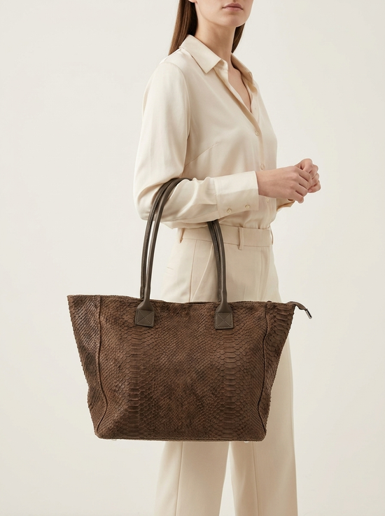 Brauner Damen-Shopper aus Veloursleder mit Kroko-Prägung, als Modell getragen