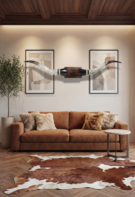 Schwarze Wanddekoration aus Leder mit Longhorns über dem Sofa in einem Wohnzimmer.