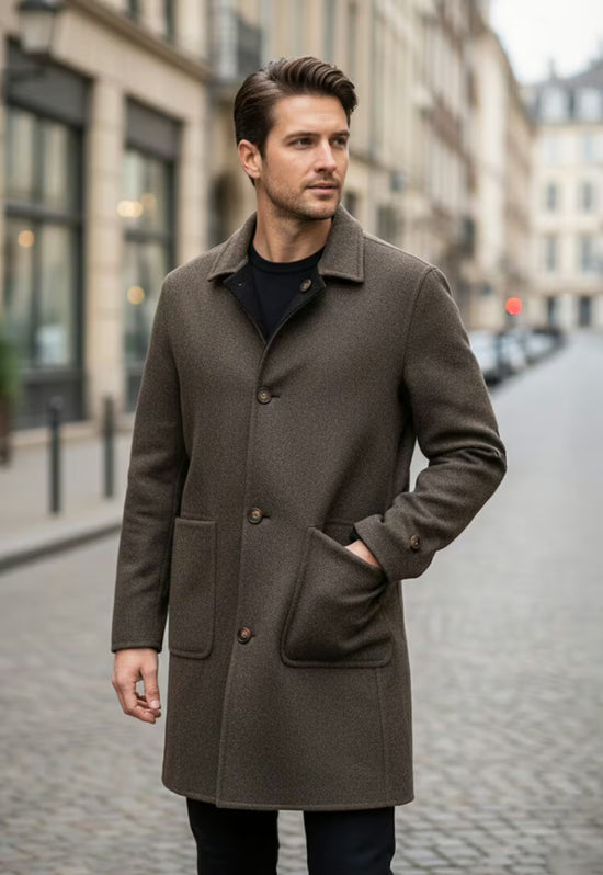 Brauner Herren-Wollmantel aus Kaschmir und Wolle im Straßenbild, offen getragen mit Hand in der Tasche.